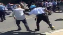 A Police officer push a man away from protesters, in this still image captured from a video footage, during a violent clash outside the Turkish ambassador's residence between protesters and Turkish security personnel during Turkish President Tayyip Erdogan's visit to Washington, DC, U.S. on May 16, 2017. Courtesy Armenian National Committee of America/Handout via REUTERS