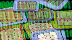 FILE PHOTO: SIM cards are reflected on a monitor showing binary digits in this picture illustration taken