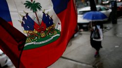 FILE PHOTO: A Flag from Haiti is pictured in a local store as a woman walks under rain at the neighborhood of Brooklyn in New York, U.S. May 13, 2017. REUTERS/Eduardo Munoz/File Photo