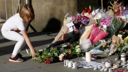 A girl leaves flowers for the victims of an attack on concert goers at Manchester Arena, in central Manchester, Britain May 23, 2017. REUTERS/Peter Nicholls
