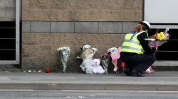 A community support officer places flowers near Manchester Arena in Manchester, Britain May 24, 2017. REUTERS/Peter Nicholls