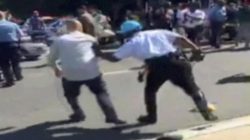A Police officer pushes a man away from protesters, in this still image captured from a video footage, during a violent clash outside the Turkish ambassador's residence between protesters and Turkish security personnel during Turkish President Tayyip Erdogan's visit to Washington, DC, U.S. on May 16, 2017. Courtesy Armenian National Committee of America/Handout via REUTERS