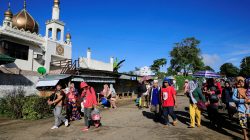 Residents carrying belongings walk past a mosque towards an evacuation center after government troops continued an assault on fighters from the Maute group who have taken over large parts of Marawi city, southern Philippines May 26, 2017. REUTERS/Romeo Ranoco