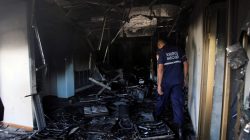 A firefighter walks past burned debris at the Ombudsman office in Maracaibo, Venezuela May 25, 2017. REUTERS/Isaac Urrutia