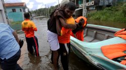 A Sri Lankan Navy rescue team member carries an old man on a flooded road during a rescue mission in Nagoda village in Kalutara, Sri Lanka May