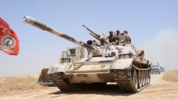 FILE PHOTO: Popular Mobilization Forces (PMF) ride on a tank during a battle with Islamic State militants, at Um Jaris village on the Iraqi border with Syria, Iraq May 29, 2017. REUTERS/Stringer/File Photo