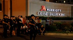 Policemen stand guard near evacuated employees of a hotel near a situation at a Resorts World building, in Pasay City, Metro Manila, Philippines June 2, 2017. REUTERS/Erik De Castro