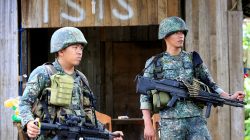 Soldiers stand guard along the main street of Mapandi village as government troops continue their assault on insurgents from the Maute group, who have taken over large parts of Marawi City, Philippines June 2,