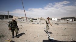 Syrian Democratic Forces (SDF) fighters walk along a damaged street in the Raqqa's al-Sanaa industrial neighbourhood, Syria June 14, 2017. Picture taken June 14, 2017. REUTERS/Rodi Said