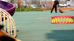 A person wearing protection on his shoes and head, sweeps near the scene of an explosion at a kindergarten in Fengxian County in Jiangsu Province, China June 16, 2017. REUTERS/Aly Song