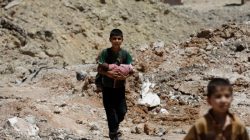 A boy carries a baby as they flee their home. REUTERS/Erik De Castro
