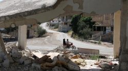 People ride a motorbike past a damaged building in a rebel-held part of the southern city of Deraa, Syria, June 15, 2017. REUTERS/Alaa Al-Faqir