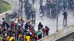 A member of the riot security forces (R) points what appears to be a pistol towards a crowd of demonstrators during a rally against Venezuela’s President Nicolas Maduro’s government in Caracas, Venezuela, June 19, 2017. REUTERS/Christian Veron