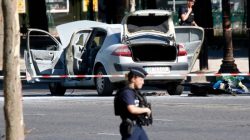 Police secure the area near a burned car at the scene of an incident in which it rammed a gendarmerie van on the Champs-Elysees Avenue in Paris, France, June 19, 2017. REUTERS/Charles Platiau