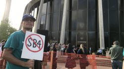A protester against the Texas state law to punish "sanctuary cities" stands outside the U.S. Federal court in San Antonio, Texas,