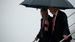 U.S. President Donald Trump (R) holds an umbrella over U.S. Ambassador to China Terry Branstad, former governor of Iowa, as they arrive together aboard Air Force One at Eastern Iowa Airport in Cedar Rapids, Iowa, U.S. June 21, 2017. REUTERS/Jonathan Ernst