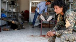 A Syrian Democratic Forces (SDF) fighter sit as medics treat his comrades injured by sniper fired by Islamic State militants in a field hospital in Raqqa, Syria June 28, 2017. REUTERS/Goran Tomasevic