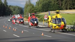 Helicopters at the site where a coach burst into flames after colliding with a lorry on a motorway near Muenchberg, Germany