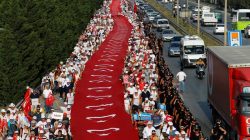 Supporters of Turkey's main opposition Republican People's Party (CHP) leader Kemal Kilicdaroglu walk with a giant Turkish flag on the 19th day of a protest, dubbed "justice march", against the detention of the party's lawmaker Enis Berberoglu, near Izmit, Turkey, July 3, 2017. REUTERS/Umit Bektas