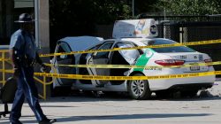 A Massachusetts State Police officer walks past the scene where a taxi cab crashed into a group of bystanders at the taxi pool at Logan International Airport in Boston, Massachusetts, U.S., July 3, 2017. REUTERS/Brian Snyder
