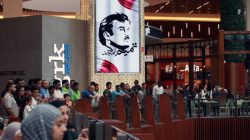 A painting depicting Qatar’s Emir Sheikh Tamim Bin Hamad Al-Thani is seen as people gather to watch players from Spain's national team in Mall of Qatar in Doha, Qatar July 5, 2017. Picture taken July 5, 2017. REUTERS/Naseem Zeitoon