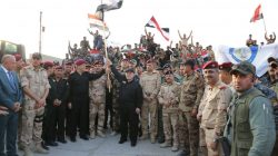 Iraqi Prime Minister Haider al-Abadi (C) holds an Iraqi flag as he announces victory over Islamic State in Mosul, Iraq, July 10, 2017. Iraqi Prime Minister Media