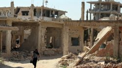 A Free Syrian Army fighter carries a weapon as he walks past damaged buildings in a rebel-held part of the southern city of Deraa, Syria July 9, 2017. REUTERS/Alaa Al-Faqir