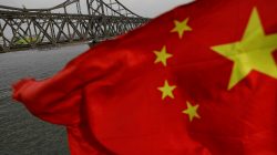 FILE PHOTO: A Chinese flag is seen in front of the Friendship bridge over the Yalu River connecting the North Korean town of Sinuiju and Dandong in China's Liaoning Province, April 1, 2017. REUTERS/Damir Sagolj/File Photo