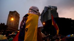 An opposition supporter stands while attending a vigil in homage to victims of violence at past protests against Venezuela's President Nicolas Maduro's government in Caracas, Venezuela, July 13, 2017. REUTERS/Andres Martinez Casares