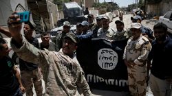 FILE PHOTO: Members of the Iraqi Army's 9th Armoured Division are photographed with an Islamic State flag, claimed after fighting with Islamic State militants in western Mosul, Iraq June 17, 2017. REUTERS/Alkis Konstantinidis/File Photo