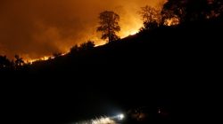 A firefighting truck is seen parked along a firebreak beneath a burning ridge during the Detwiler fire in Mariposa, California. REUTERS/Stephen Lam