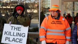 A protester (L) and an escort who ensures women can reach the clinic stand outside the EMW WomenÕs Surgical Center in Louisville, Kentucky, U.S. January 27, 2017. REUTERS/Chris Kenning