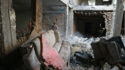 FILE PHOTO: People are seen amid debris at a damaged site in Arbin, a town in Damascus countryside, Syria. REUTERS/Bassam Khabieh