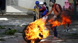 Demonstrators use a tire on fire to block a street at a rally during a strike called to protest against Venezuelan President Nicolas Maduro's government in Caracas, Venezuela July 26, 2017. REUTERS/Andres Martinez Casares