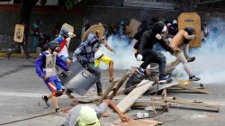 Demonstrators run away at a rally against Venezuelan President Nicolas Maduro's government in Caracas. REUTERS/Carlos Garcia Rawlins