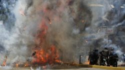 Flames erupt as clashes break out near security forces members (R) while the Constituent Assembly election is being carried out in Caracas, Venezuela,