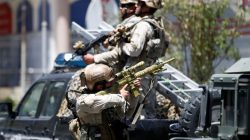 A member of the Afghan security forces aims his rifle during gun fire at the site of an attack in Kabul, Afghanistan July 31