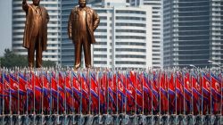 FILE PHOTO: People carry flags in front of statues of North Korea founder Kim Il Sung (L) and late leader Kim Jong Il during a military parade marking the 105th birth anniversary Kim Il Sung, in Pyongyang April 15, 2017. REUTERS/Damir Sagolj