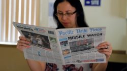A hotel receptionist reads a local newspaper in Tamuning, Guam, a U.S. Pacific Territory, August 12, 2017. REUTERS/Erik De Castro