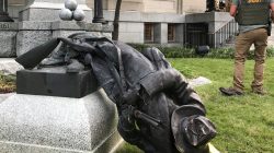A Sheriff's deputy stands near the toppled statue of a Confederate soldier in front of the old Durham County Courthouse in Durham, North Carolina, U.S. August 14, 2017. REUTERS/Kate Medley