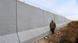 A Kurdish People's Protection Units (YPG) fighter walks near a wall, which activists said was put up by Turkish authorities, on the Syria-Turkish border in the western countryside of Ras al-Ain, Syria January 29, 2016. REUTERS/Rodi Said