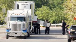 FILE PHOTO: Police officers work on a crime scene after eight people believed to be illegal immigrants being smuggled into the United States were found dead inside a sweltering 18-wheeler trailer parked behind a Walmart store in San Antonio, Texas, U.S. July 23, 2017. REUTERS/Ray Whitehouse/File Photo