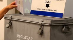 FILE PHOTO: A ballot is placed into a locked ballot box by a poll worker as people line-up to vote early at the San Diego County Elections Office in San Diego, California, U.S., November 7, 2016. REUTERS/Mike Blake/File Photo