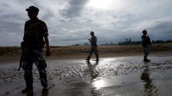 FILE PHOTO: A Myanmar border guard police officers stand guard in Buthidaung, northern Rakhine state, Myanmar July 13, 2017. REUTERS/Simon Lewis/File Photo