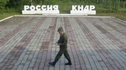 A guard walks along a platform past signs, which read "Russia" (L) and "DPRK"(Democratic People's Republic of Korea), at the border crossing between Russia and North Korea in the settlement of Tumangan, North Korea July 18, 2014.