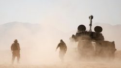 Hezbollah fighter walk near a military tank in Western Qalamoun, Syria August 23, 2017.