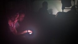 Women are illuminated by the light of a smart phone as they seek refuge in the Good Samaritan Rescue Mission in Corpus Christi.