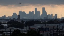 A helicopter hovers above the Houston skyline as sunlight breaks through storm clouds from Tropical Storm Harvey in Texas, U.S. August 29, 2017. REUTERS/Adrees Latif