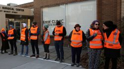 FILE PHOTO: Escorts who ensure women can reach the clinic lineup as they face off protesters outside the EMW Women's Surgical Center in Louisville, Kentucky, U.S. on January 27, 2017. P REUTERS/Chris Kenning/File Photo