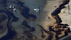 Vehicles sit amid leaked fuel mixed in with flood waters caused by Tropical Storm Harvey in the parking lot of Motiva Enterprises LLC in Port Arthur, Texas, U.S. August 31, 2017.
